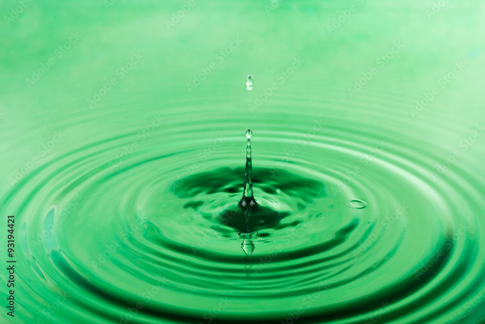 Drop of water falling into the green water Drop of water falling into the green water