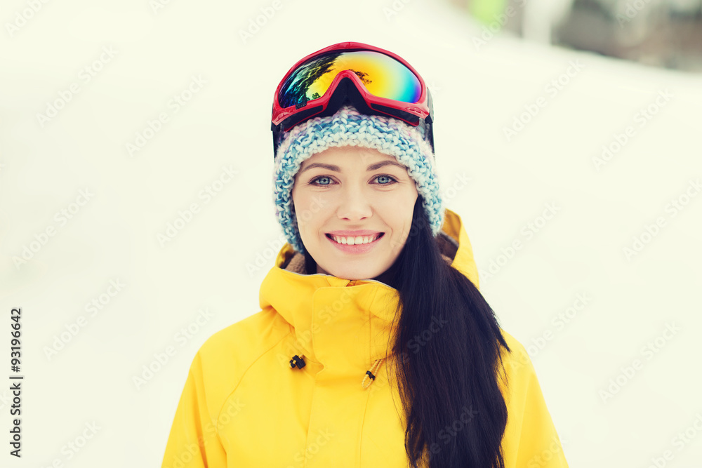 happy young woman in ski goggles outdoors