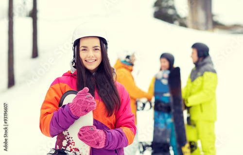 happy friends in helmets with snowboards