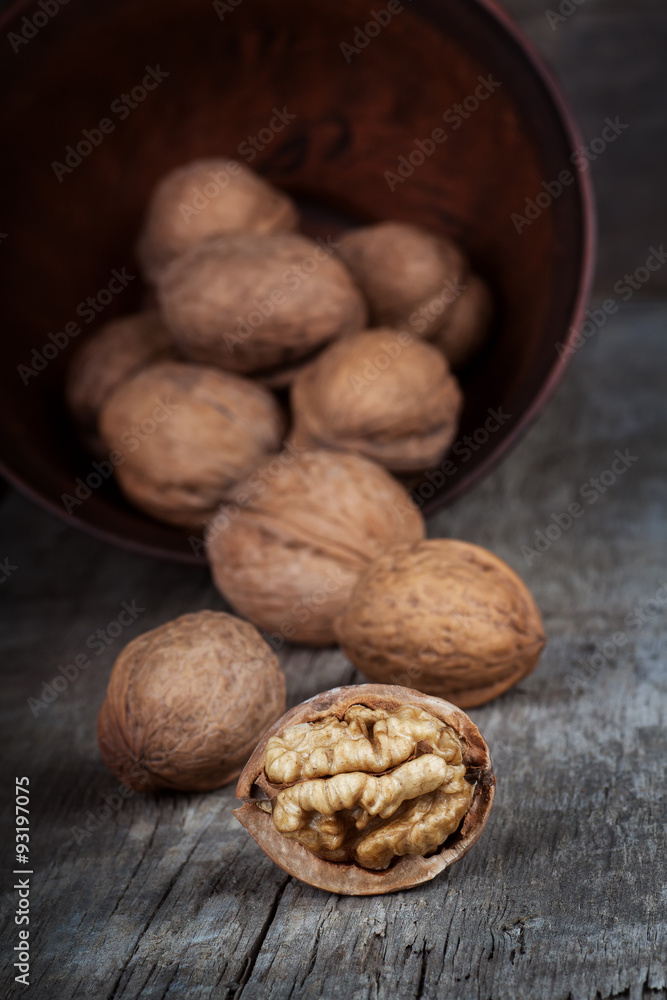 Whole and half walnut in clay bowl Whole and half walnut in clay bowl