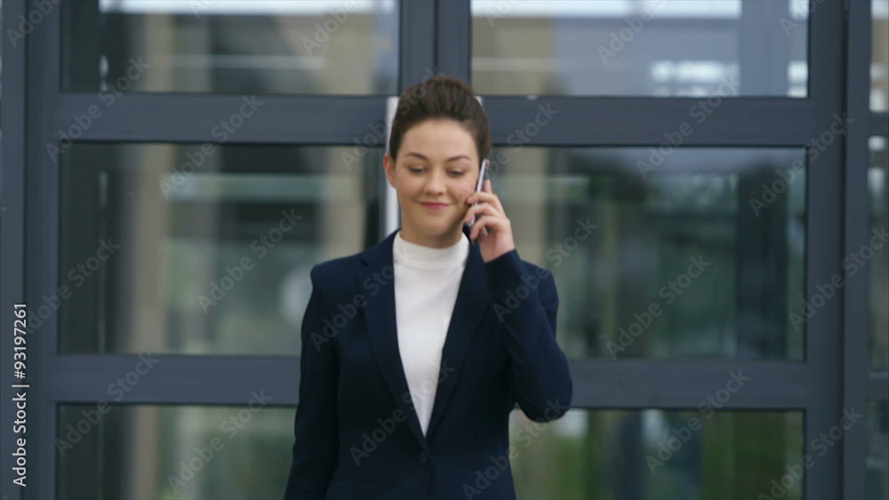 Slow motion video of confident businesswoman using smart phone. Beautiful professional leaving from office. She is walking outside office building. Slow motion video of confident businesswoman using smart phone. Beautiful professional leaving from office. She is walking outside office building.