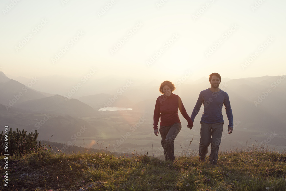Austria, Tyrol, couple walking hand in hand at Unterberghorn at sunset Austria, Tyrol, couple walking hand in hand at Unterberghorn at sunset