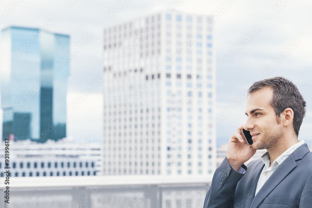 Businessman on urban balcony talking on cell phone Businessman on urban balcony talking on cell phone