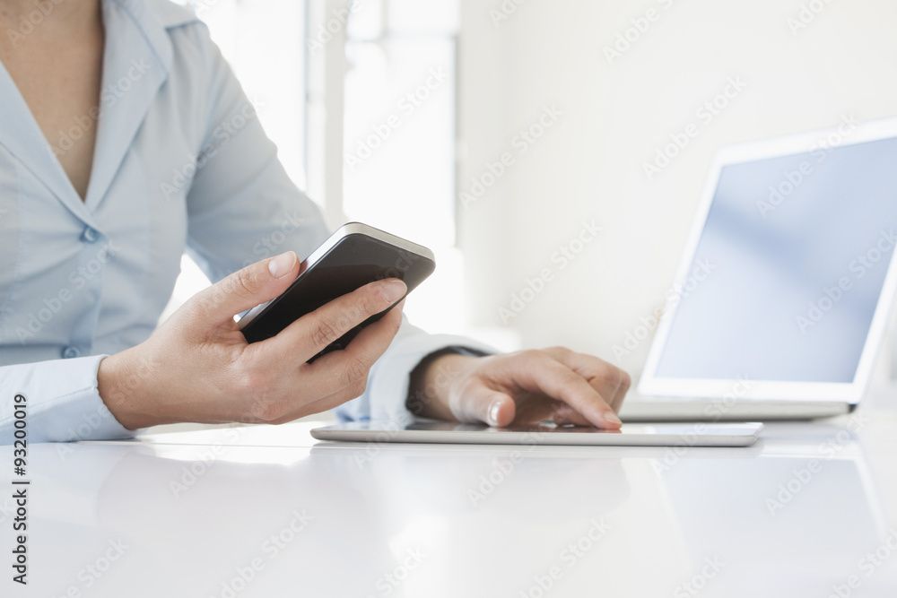 Close-up of woman's hands using smartphone and digital tablet Close-up of woman's hands using smartphone and digital tablet