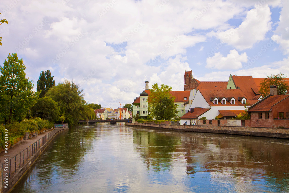 Landshut, Germany - romantic view of the pedestian walk along the Isar river with lush vegetation and the characteristic Renaissance houses