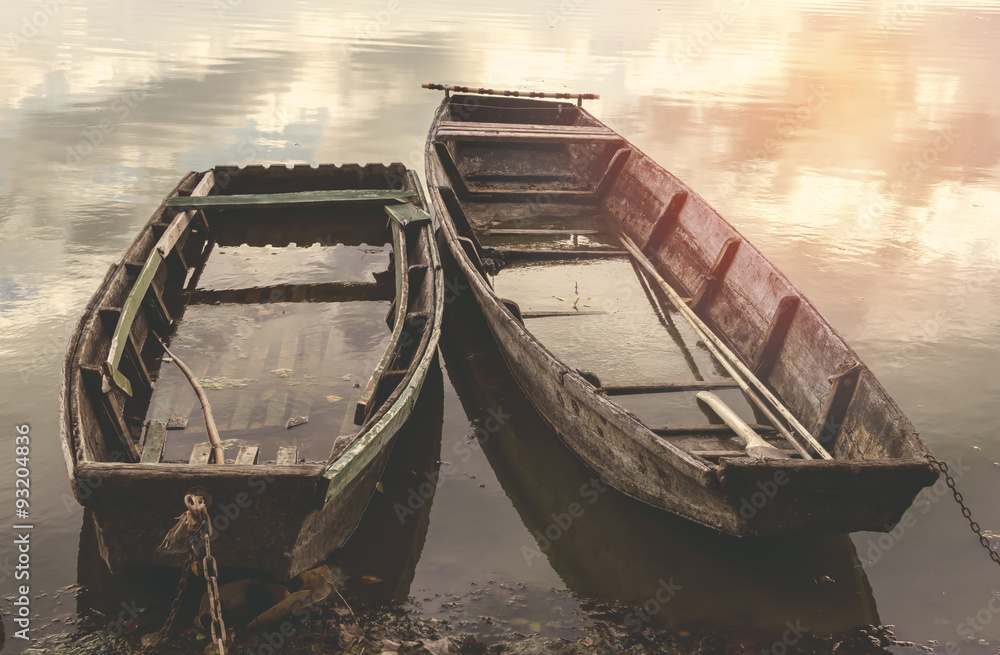 Old flooded wooden boats on river