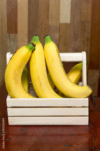 bananas in the basket on wooden table.