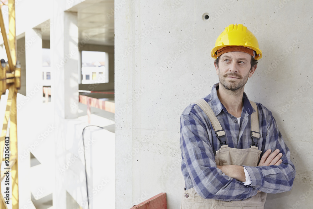 Man with hard hat on construction site thinking Man with hard hat on construction site thinking