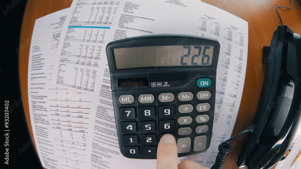 Businessman calculating data and calling by phone Businessman calculating data and calling by phone