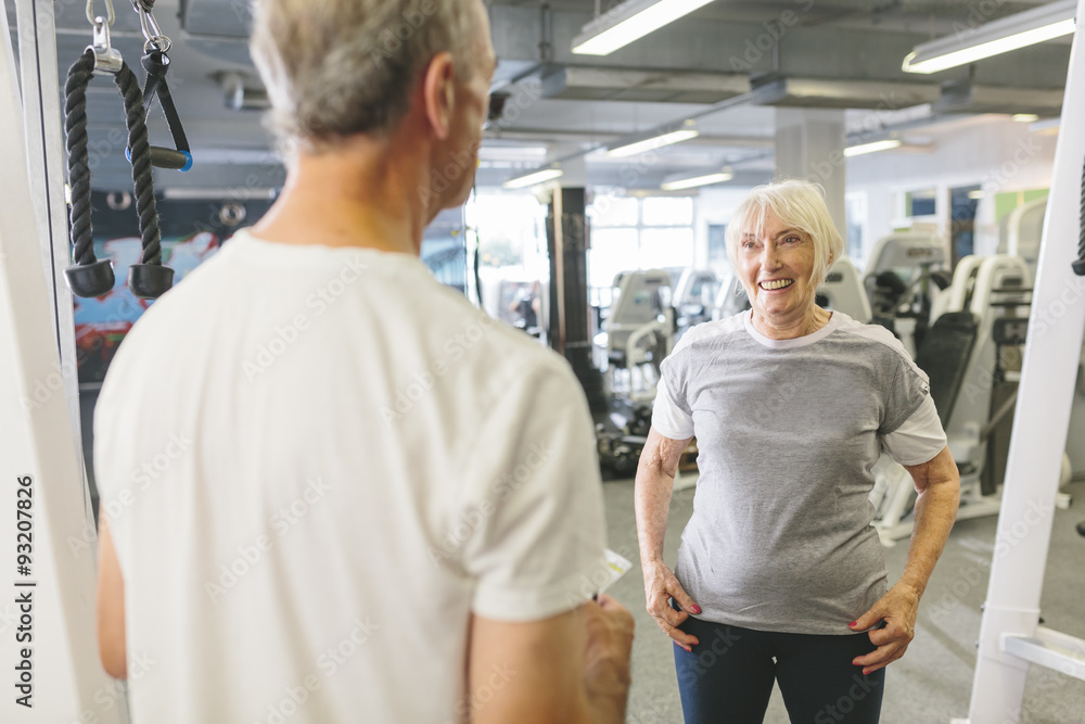 Senior woman smiling at man in gym Senior woman smiling at man in gym