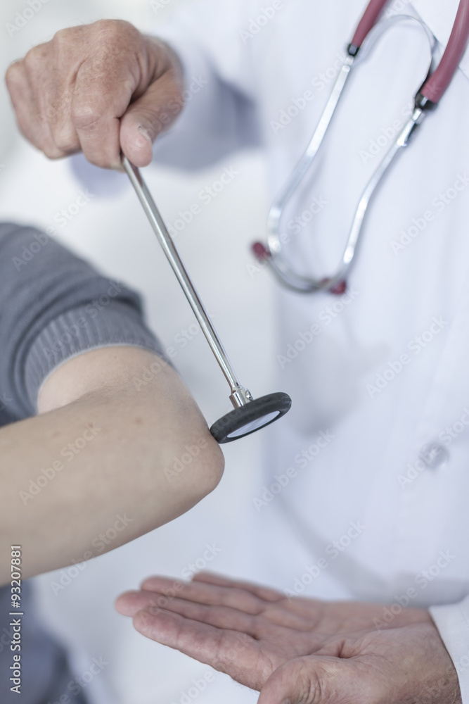 Doctor tapping patient with reflex hammer StockFoto Adobe Stock