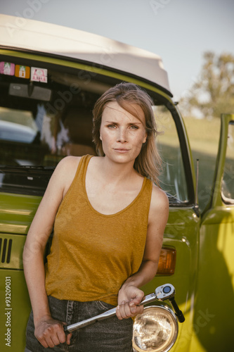 Woman holding a torque wrench at van