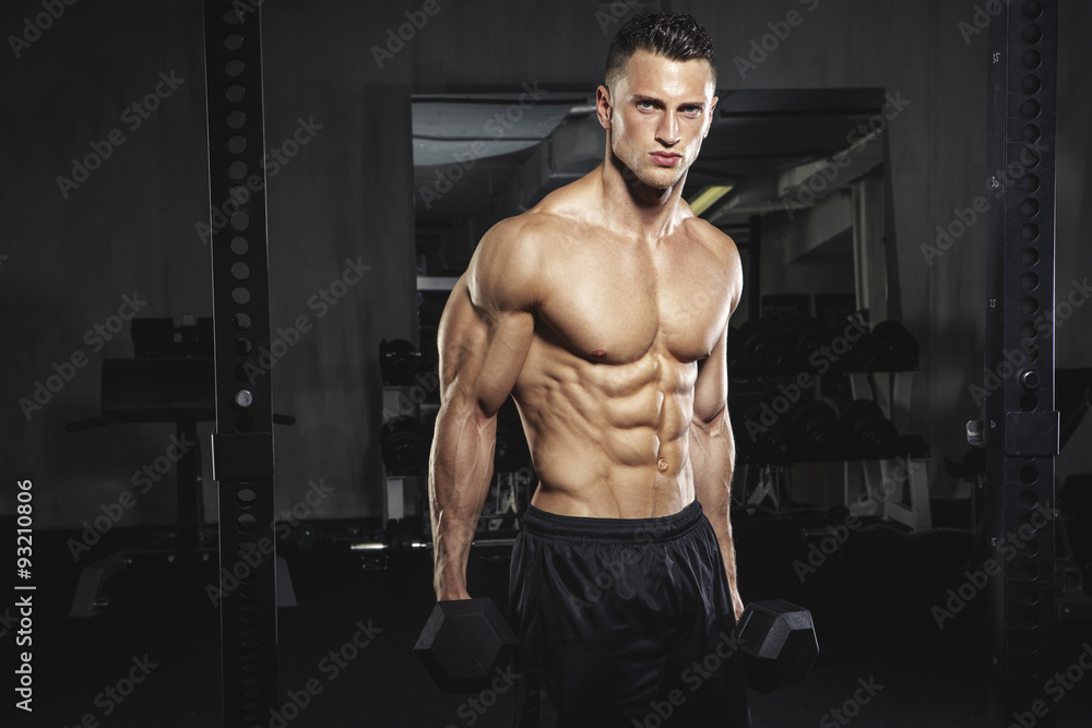 Physical athlete exercising with dumbbells Physical athlete exercising with dumbbells