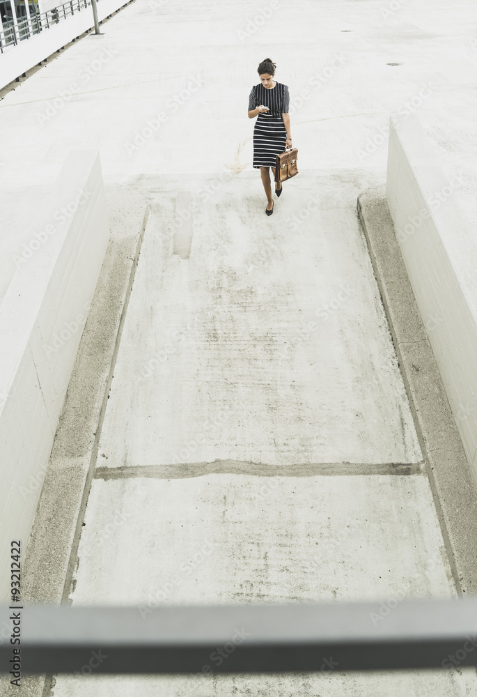 Young businesswoman walking on parking deck Young businesswoman walking on parking deck