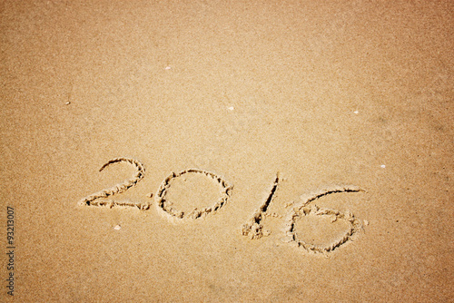 new year 2016 written in sandy beach. image is retro filtered 