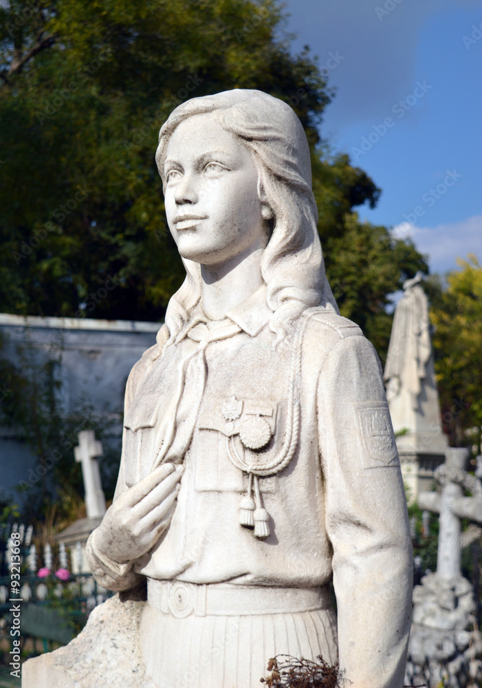 Statue of young girl in Pioneer uniform on grave in Bucharest