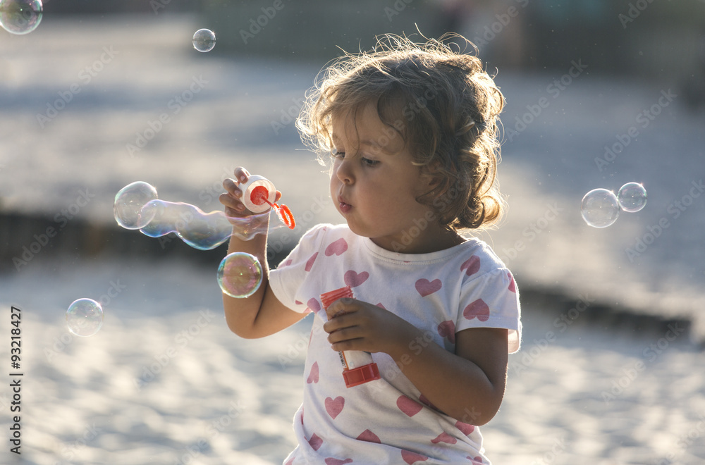 Little girl making soap bubbles at playground Little girl making soap bubbles at playground
