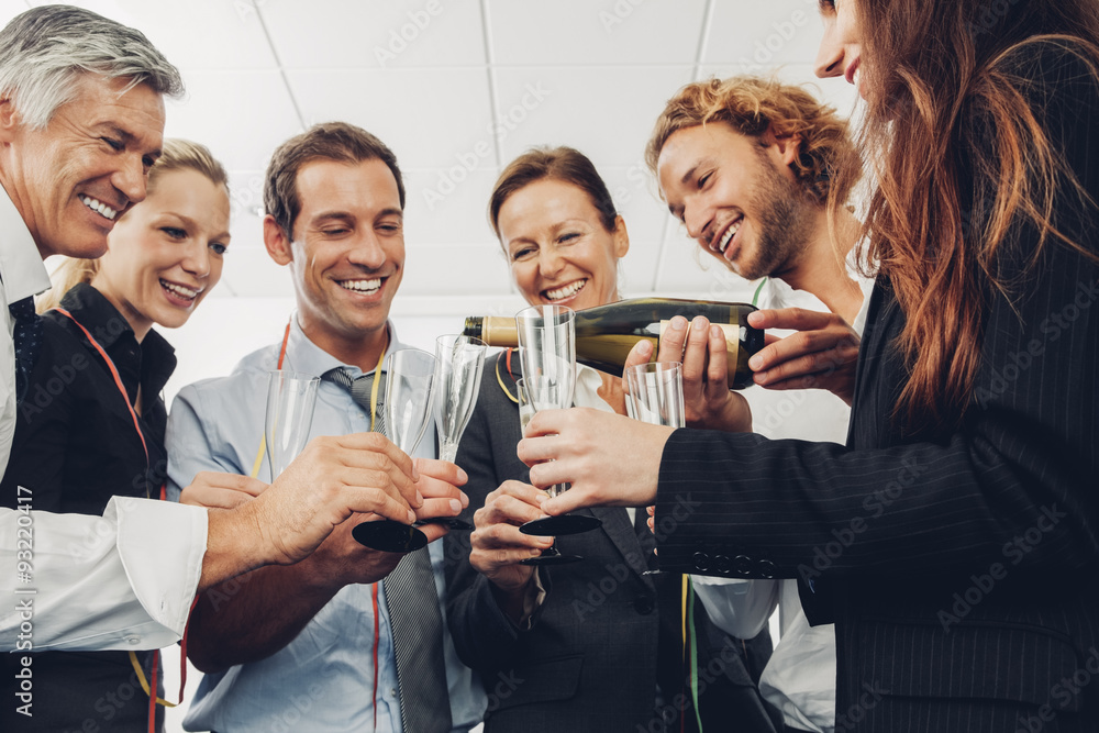 Group of business people raising a toast with champagne at office Group of business people raising a toast with champagne at office