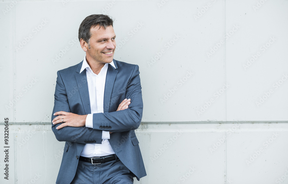 Businessman leaning on wall with arms crossed Businessman leaning on wall with arms crossed