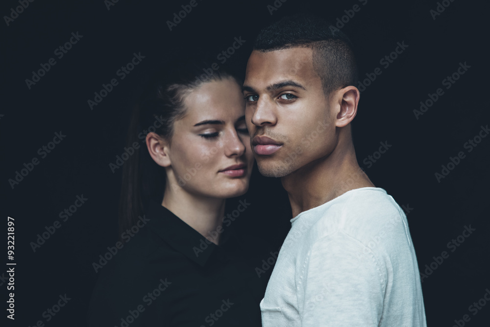 Portrait of young couple head to head in front of black background Portrait of young couple head to head in front of black background