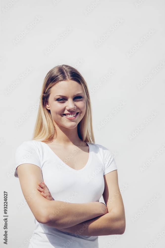Portrait of smiling young woman with crossed arms in front of white background Portrait of smiling young woman with crossed arms in front of white background