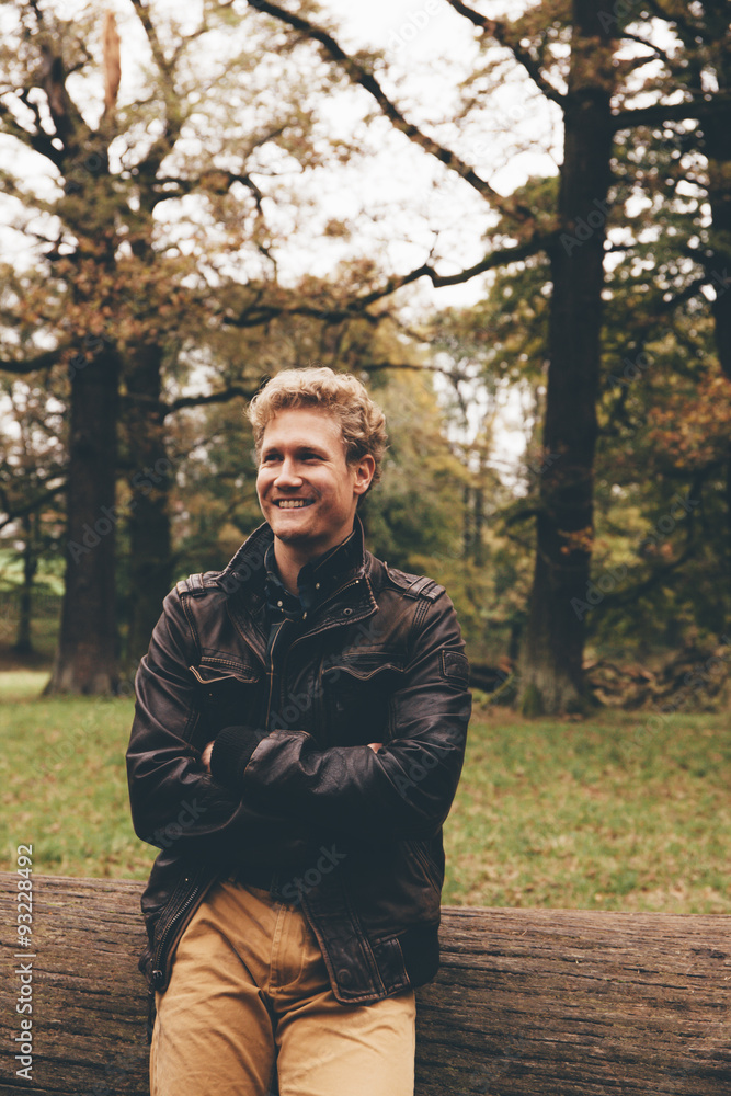 Portrait of smiling young man with crossed arms in autumnal park Portrait of smiling young man with crossed arms in autumnal park