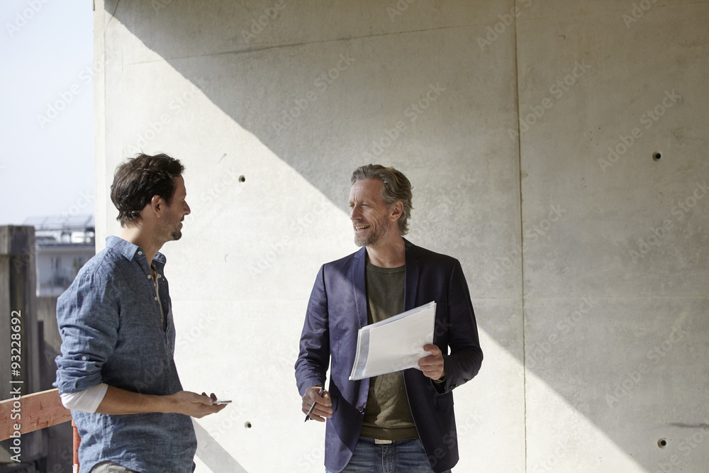 Two men talking on construction site Two men talking on construction site