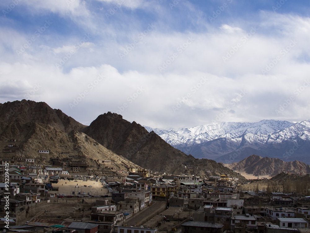 Leh town under the shadow of clouds with the snow mountain backg