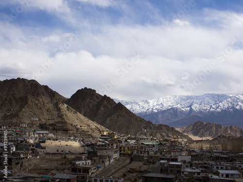 Leh town under the shadow of clouds with the snow mountain backg