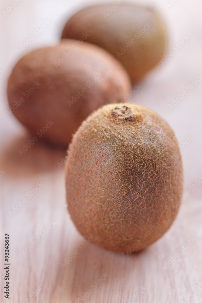 Three kiwis on the wood table. Shallow depth of field. Three kiwis on the wood table. Shallow depth of field.