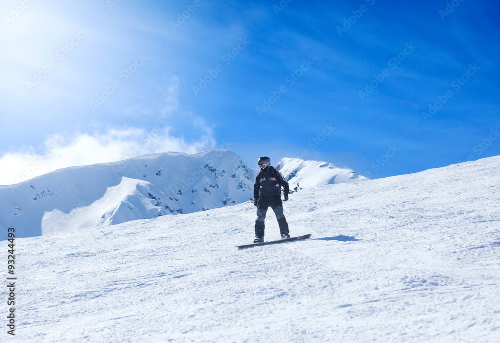 Young man snowboarding on the mountain