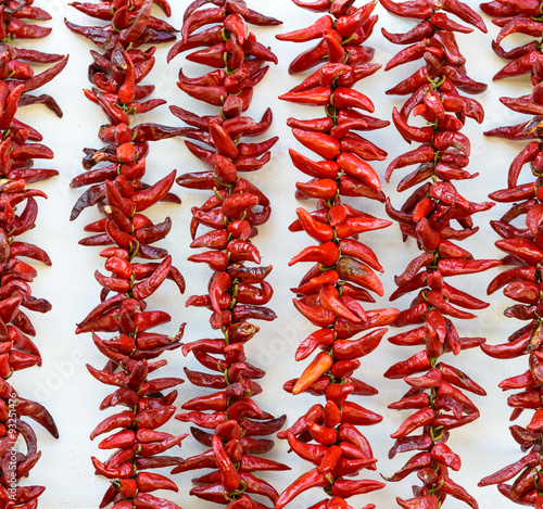 Strings of PDO Espelette chilli peppers drying photo