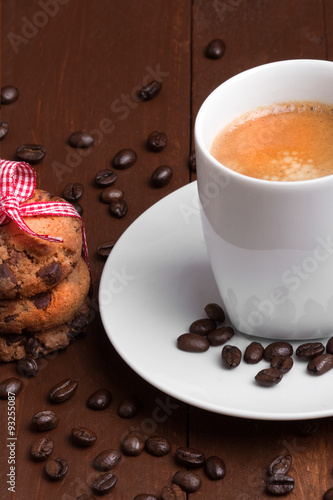Brewed coffee with fruit cake and grains on a wooden background
