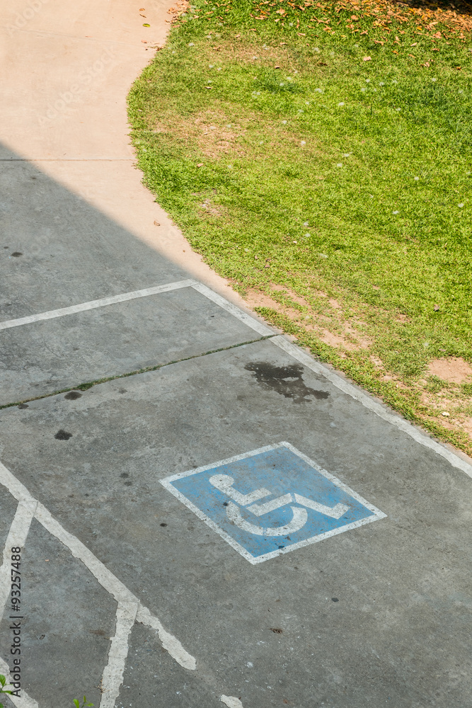 Obraz premium parking space reserved handicapped on road with disabled sign