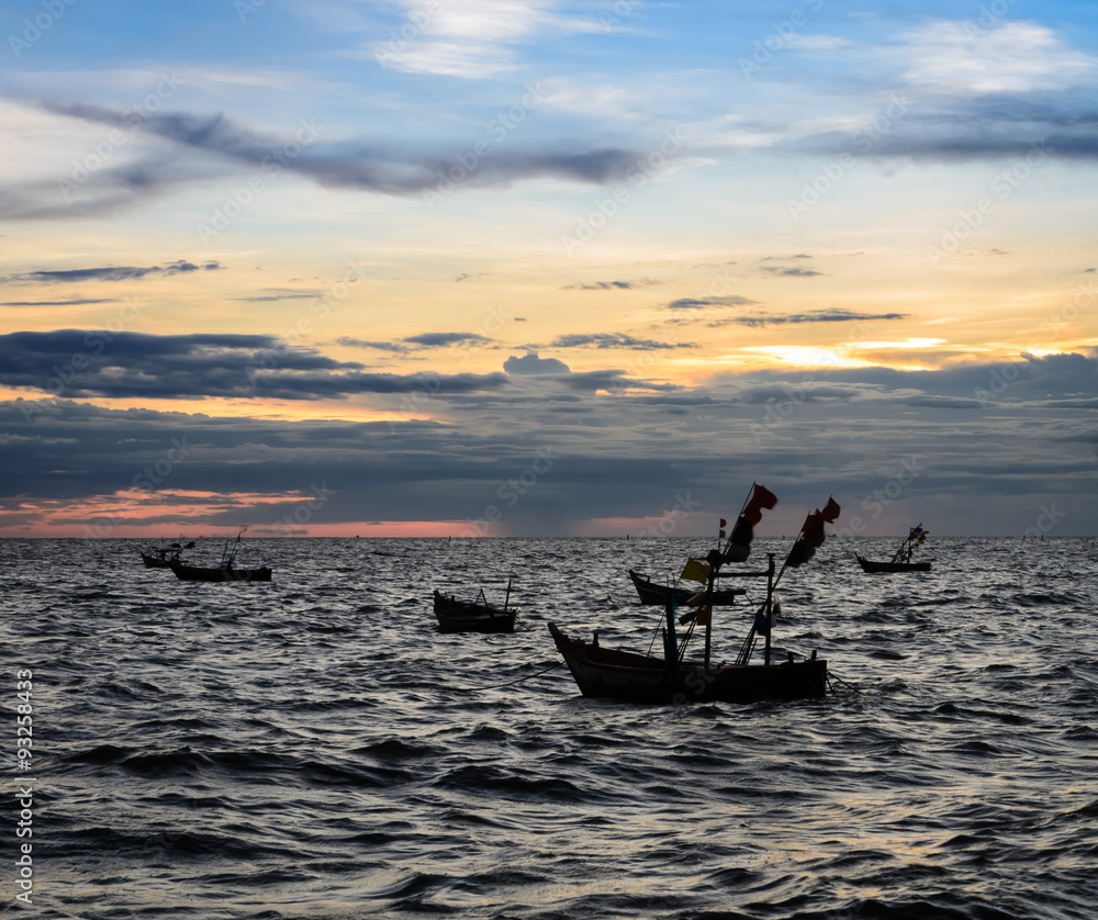 Dramatic sunset sky on the sea with fishing boat