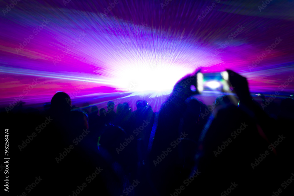 Naklejka premium Laser show party rays in front of smartphone filming video. Best visual show with a crowd silhouette and great laser rays for e.g. an illustration background of an invitation flyer