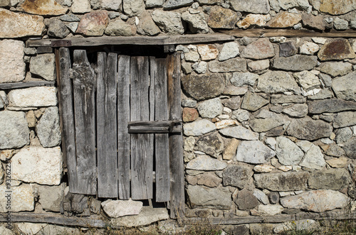 Old stone wall with wooden padlocked door