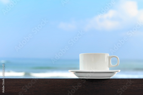 White coffee cup on blur beach and blue sky background