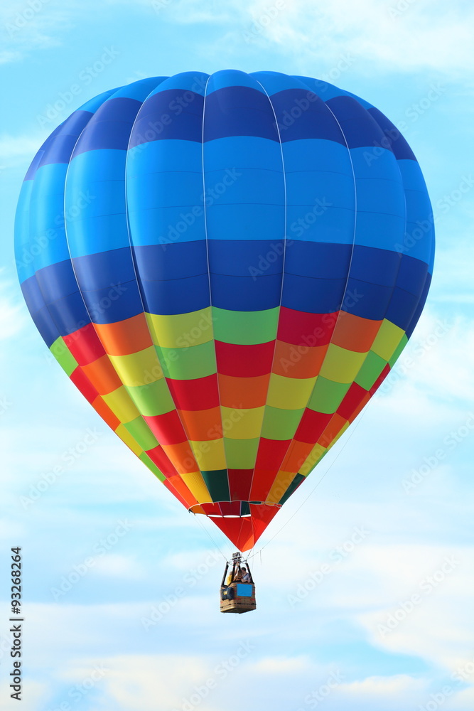 Fototapeta premium Brightly colored hot air balloon with a sky blue background