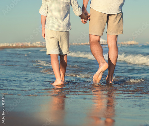 Father and son legs on the sea surfline close up image