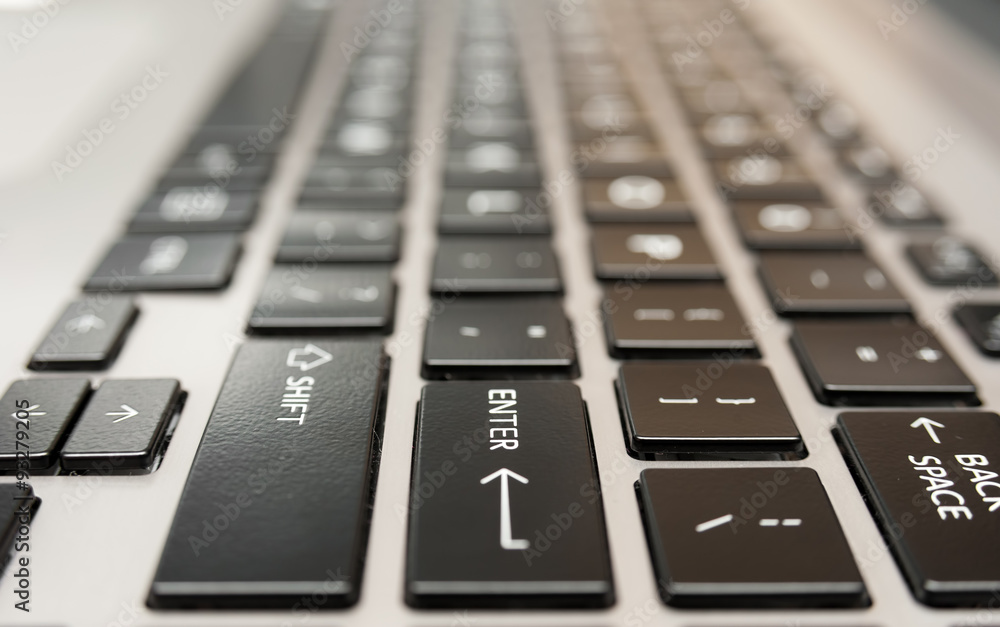 Laptop computer keyboard close up with red enter key button Laptop computer keyboard close up with red enter key button