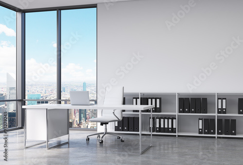 A CEO workplace in a modern corner panoramic office in New York city. A white desk with a laptop, white leather chair and a bookshelf with black document folders. 3D rendering. photo