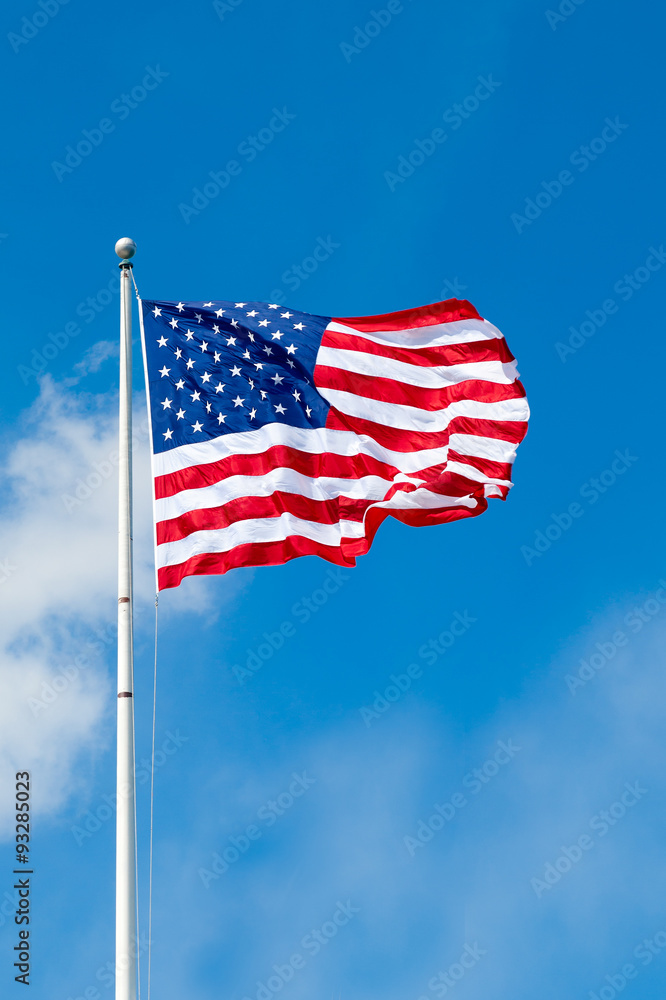 American flag waving against blue sky. Copy space.