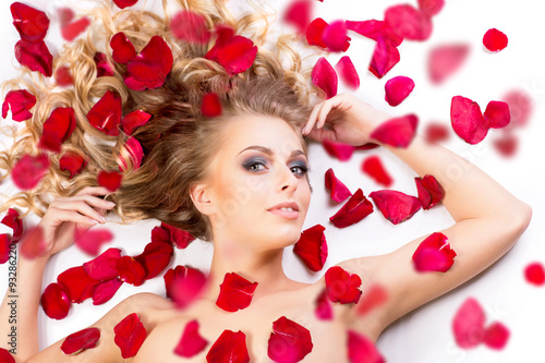 Beautiful and sexy model with rose petals, isolated on white bac