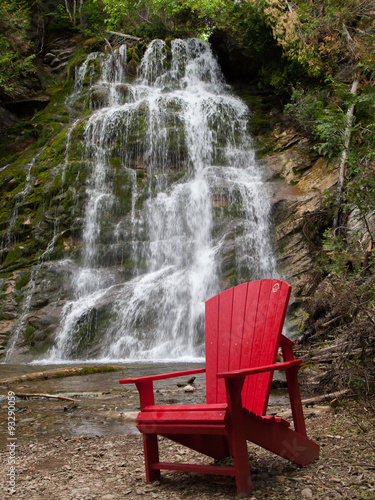 Red chair in front La Chute waterfall, Forillon National Park, Gaspe Peninsula, Quebec photo