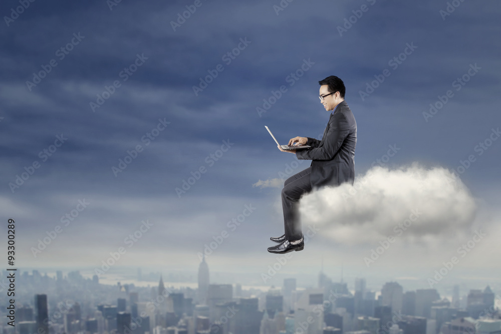 Businessman using laptop on the cloud Businessman using laptop on the cloud