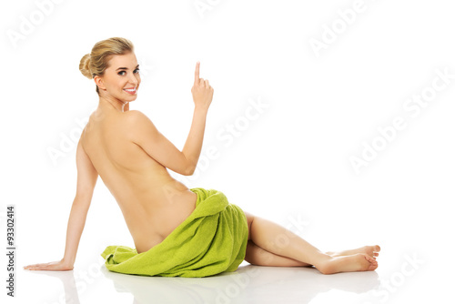 Young happy woman after bath or spa sitting on the floor