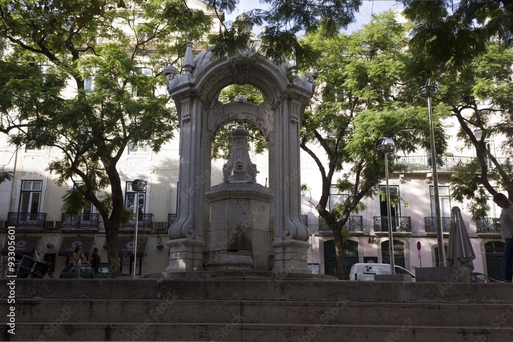 Largo do Carmo fountain in Lisbon, in front of the ruins of the convent, surrounded by trees