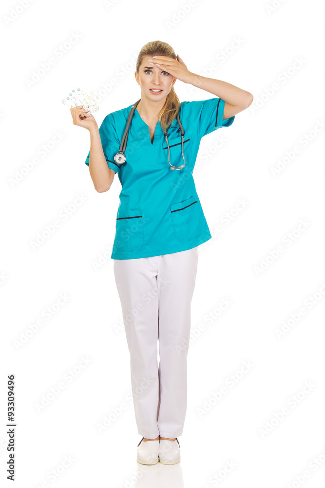 Shocked female nurse or doctor holding pills Shocked female nurse or doctor holding pills