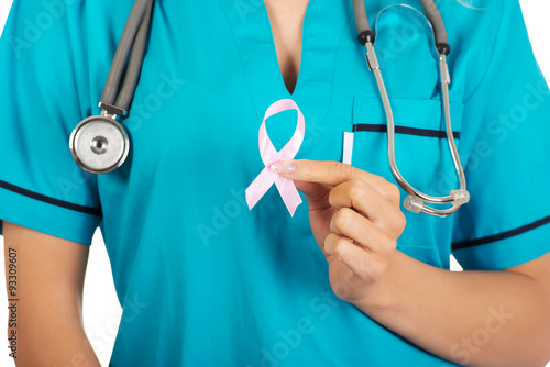 Smiling nurse holding pink breast cancer awareness ribbon. 